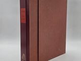 a book with a red cover sitting on top of a white surface