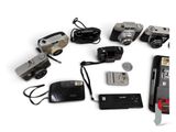 many different types of cameras and electronics laid out on a white surface