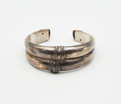 a close up of a silver bracelet on a white surface