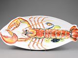 a plate with a lobster on it on a gray surface