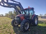 un tracteur rouge garé dans l'herbe