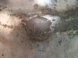 a large metal vase with a bird emblem on it