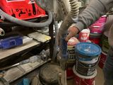 a woman that is working on a fan in the garage