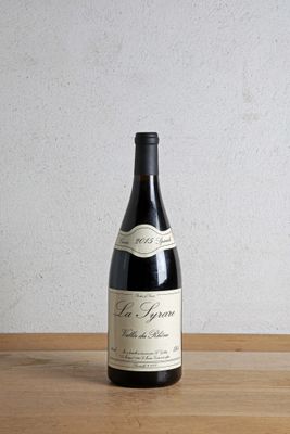 a bottle of wine sitting on a table next to a bottle of wine