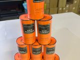 several cans of orange paint stacked on top of each other on a table