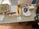 un bureau sur lequel se trouvent un téléphone et d'autres fournitures de bureau