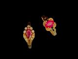 une paire de boucles d'oreilles roses et dorées sur fond noir