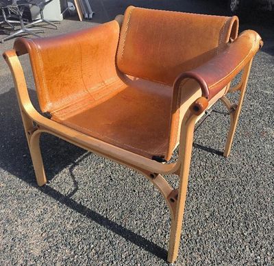 un fauteuil en cuir marron posé à même le sol
