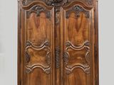 une armoire ancienne en bois, ornée de sculptures sur les portes