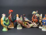 several figurines of different types of birds on a black background