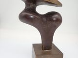 bronze sculpture of a curved piece of wood on a wooden base