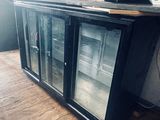 an image of a glass door refrigerator in a room