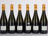 six bouteilles de vin sont alignées sur une surface blanche