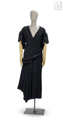mannequin vêtu d'une robe noire à jupe plissée, exposé en vitrine