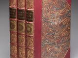 deux livres rouges à la reliure dorée, posés côte à côte