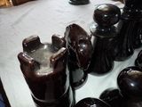 a lot of vases sitting on a table with a white table cloth