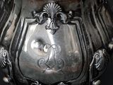 a silver vase that has a monogram on it