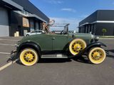 an old car parked in a parking lot in front of a building