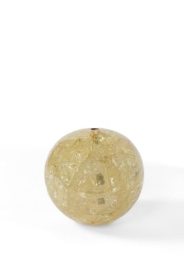 boule de verre jaune posée sur une surface blanche, sur fond blanc