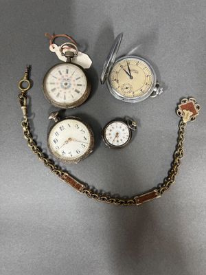 many different types of pocket watches on the table