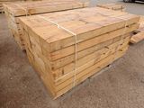 many pieces of wood stacked on top of each other in a parking lot