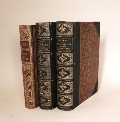trois livres sont empilés sur une surface blanche