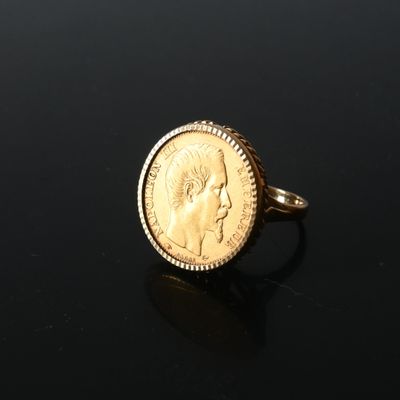 a close up of a gold coin ring on a black surface