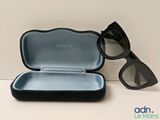 une paire de lunettes de soleil posée sur une table à côté d'un étui