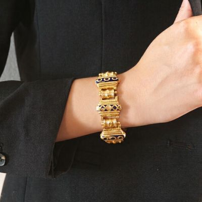 une femme portant un bracelet en or et une veste noire