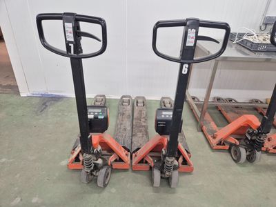 deux chariots élévateurs orange placés l'un à côté de l'autre sur le sol
