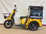 a yellow scooter parked in front of a white wall