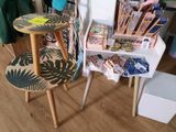 une table avec deux tabourets et une table recouverte d'une nappe