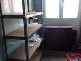 a room with a shelf and a red bin in it
