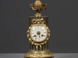 l'image d'une horloge en or posée sur une table