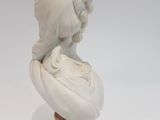marble bust of a woman on a pedestal with a hat on her head