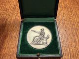 an image of a small box with a medal in it on a wooden table