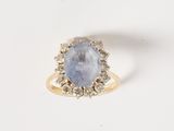 a blue sapphire and diamond ring on a white surface