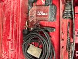 une boîte à outils rouge contenant une perceuse et d'autres outils