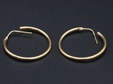 une paire de boucles d'oreilles en or sur fond noir