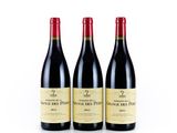 three bottles of red wine sit side by side on a white surface