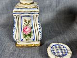 a small vase with a flower on it next to a small plate