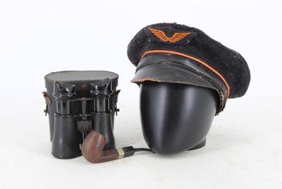 un chapeau, une pipe et un porte-pipe posés sur une surface blanche