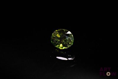 gros plan d'un diamant vert sur une surface noire