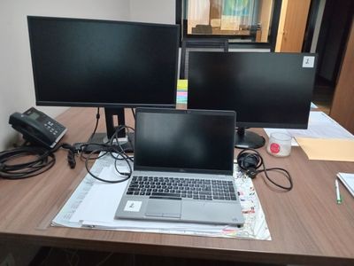 a laptop computer sitting on top of a wooden desk