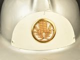 a white hard hat with a gold emblem on it