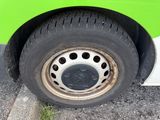 a close up of a tire on a green bus