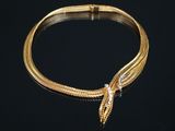 un gros plan d'un bracelet en or orné d'une tête de serpent