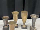 cinq vases posés sur une table, sur fond noir