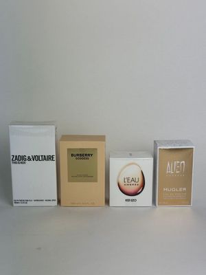 three boxes of perfume sitting next to each other on a white surface
