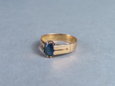 an image of a gold ring with a blue stone